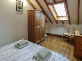 A bedroom with a bed and wardrobe at Tyn y Mynydd in Bull Bay