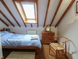 A bedroom with a bed and dresser at Tyn y Mynydd Bull Bay