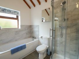 A bathroom with a bathtub and shower at Tyn y Mynydd in Bull Bay