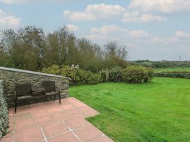 A garden with a bench and table at Tyn y Mynydd Bull Bay