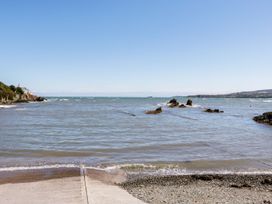 A view of the sea with rocks and a pier at Tyn y Mynydd in Bull Bay