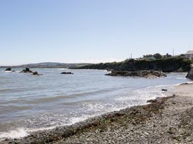 A beach with rocks and water at Tyn y Mynydd in Bull Bay