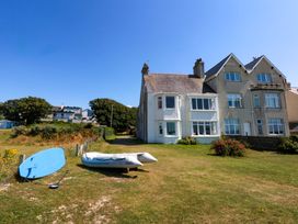 A house with a kayak and paddleboard in a garden at Windygates in Rhosneigr