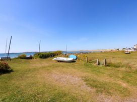 A view of the sea with boats and grass at Windygates in Rhosneigr
