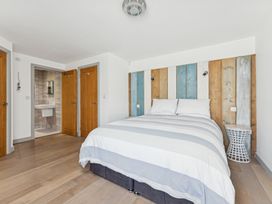 A bedroom with a bed and bathroom access at Ysbryd y Mynydd in South Stack