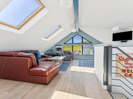 A living room with a brown sofa and coffee table at Ysbryd y Mynydd in South Stack