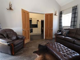 A living room with a sofa and armchair at Clwyd Cottage in St Asaph