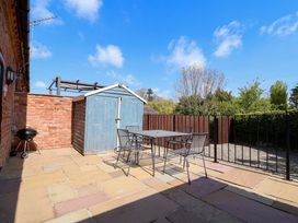 A garden with a table and chairs next to a shed at Clwyd Cottage in St Asaph