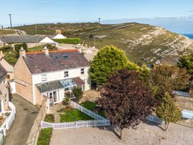 A house with a garden and trees at Ty Bach, Great Orme, Llandudno