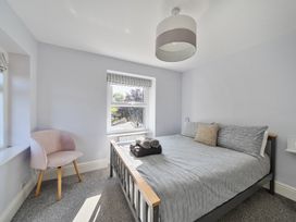 A bedroom with a bed and chair at Ty Mawr, Great Orme in Llandudno