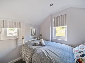 A bedroom with a bed and windows at Ty Mawr, Great Orme in Llandudno