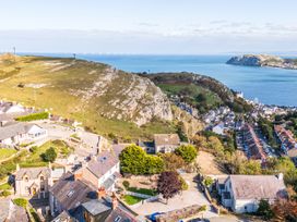 A view of hills and ocean with houses in Llandudno