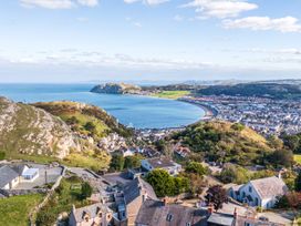 A coastal view of a town with hills and sea at Ty Mawr, Great Orme in Llandudno