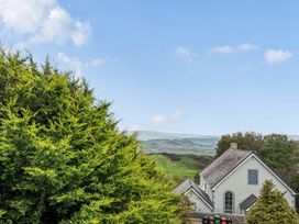A view of hills and a house with trees at Ty Mawr, Great Orme in Llandudno