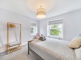 A bedroom with a bed and a clothes rack at Ty Mawr, Great Orme Llandudno