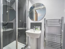 A bathroom with a shower, sink, and towel radiator at Ty Mawr, Great Orme in Llandudno
