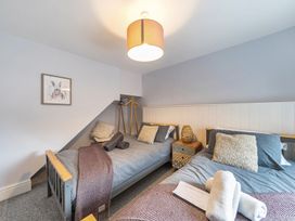A bedroom with two beds and a side table at Ty Mawr, Great Orme in Llandudno