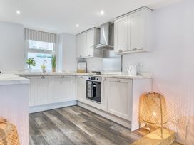 A kitchen with cabinets, sink, and oven at Ty Mawr, Great Orme in Llandudno