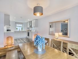 A dining room with a table and flowers at Ty Mawr, Great Orme in Llandudno