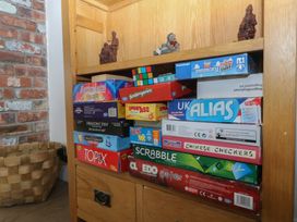 A bookshelf with board games and figurines at Llanallgo Church Rooms