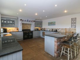 A kitchen with cabinets and appliances at Llanallgo Church Rooms