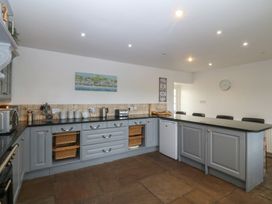 A kitchen with gray cabinets and countertop at Llanallgo Church Rooms in 