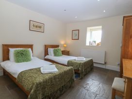 A bedroom with two beds and a window at Llanallgo Church Rooms