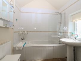 A bathroom with a bathtub, sink, and shower at Llanallgo Church Rooms in 