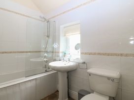 A bathroom with a shower, sink, and toilet at Llanallgo Church Rooms