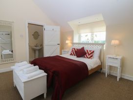 A bedroom with a bed and a mirror at Llanallgo Church Rooms