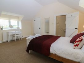 A bedroom with a bed and a table at Llanallgo Church Rooms