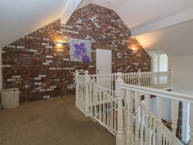 A hallway with a staircase and wall art at Llanallgo Church Rooms 