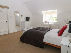 A bedroom with a bed and dresser at Llanallgo Church Rooms 