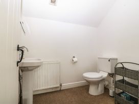 A bathroom with a sink, toilet, and radiator at Llanallgo Church Rooms