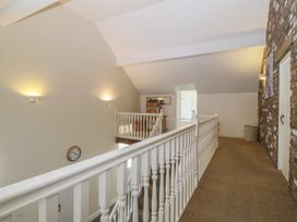 A hallway with a handrail and clock at Llanallgo Church Rooms