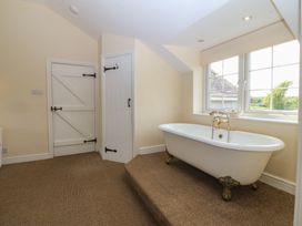 A bathroom with a bathtub and window at Llanallgo Church Rooms 