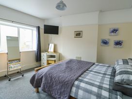 A bedroom with a bed and television at Sea Breeze in Rhos-on-Sea
