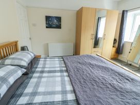 A bedroom with a bed and wardrobe at Sea Breeze in Rhos-on-Sea