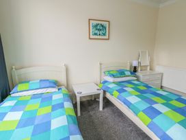 A bedroom with two beds and a table at Sea Breeze in Rhos-on-Sea