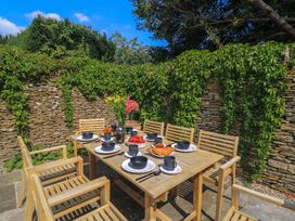 An outdoor dining area with a table and chairs at Easter Cottage in Burford
