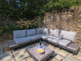 A garden with an outdoor sofa and coffee table at Easter Cottage in Burford