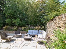 An outdoor seating area with a coffee table and flowers at Easter Cottage in Burford