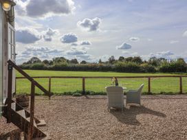 An outdoor seating area with a table and chairs at The Shepherds Hut in Chippenham