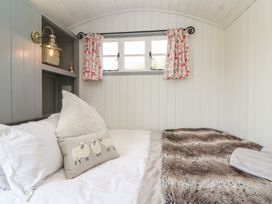 A bedroom with a bed and pillows at The Shepherds Hut in Chippenham