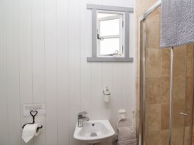 A bathroom with a sink and shower at The Shepherds Hut in Chippenham
