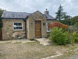 A stone cottage with a door and windows at Gowanlea in Bellingham