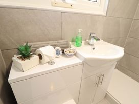 A sink with a soap dispenser and decorative items at Moggs Retreat in Chapel St Leonards