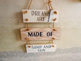 A wooden sign with the text 'DREAMS ARE MADE OF SAND AND SUN' at Moggs Retreat in Chapel St Leonards