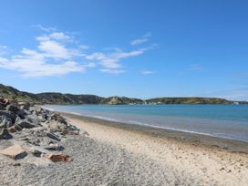 A beach with rocks and water at Happy Daze in Morfa Nefyn