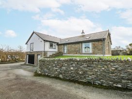 A house with a garage and a stone wall at Bwthyn Alberts Trearddur Bay